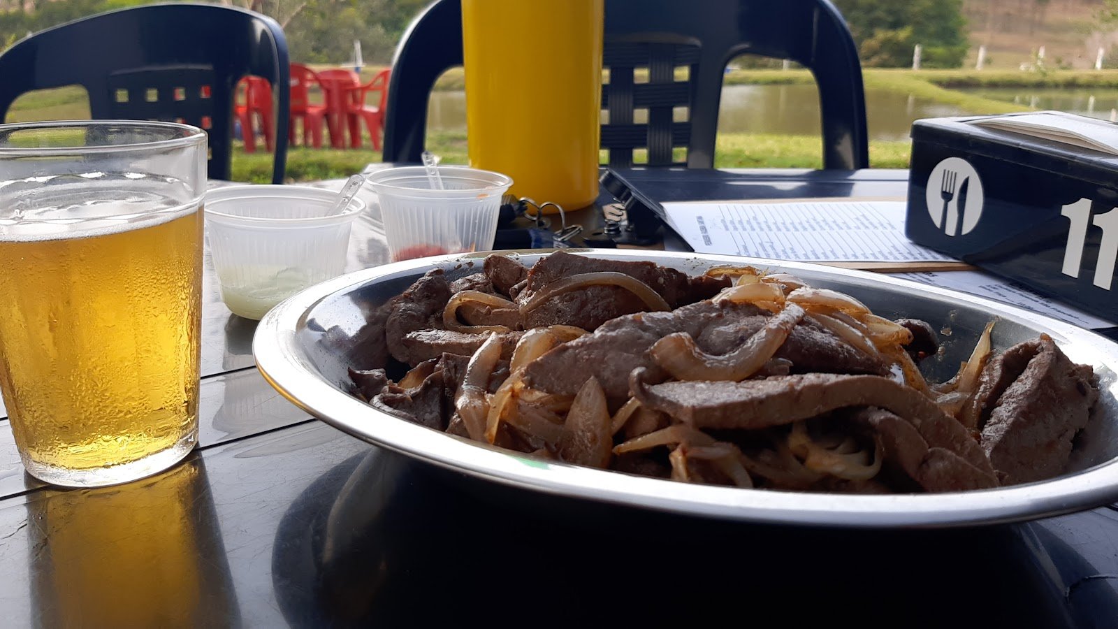 Porção e cerveja à mesa no Pesqueiro Fazenda Santana, em Analândia (SP)