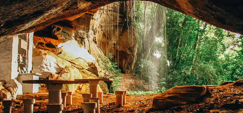 Gruta Nossa Senhora de Lourdes em Analândia (SP), interior de rocha com altar, mesas e abertura para a mata