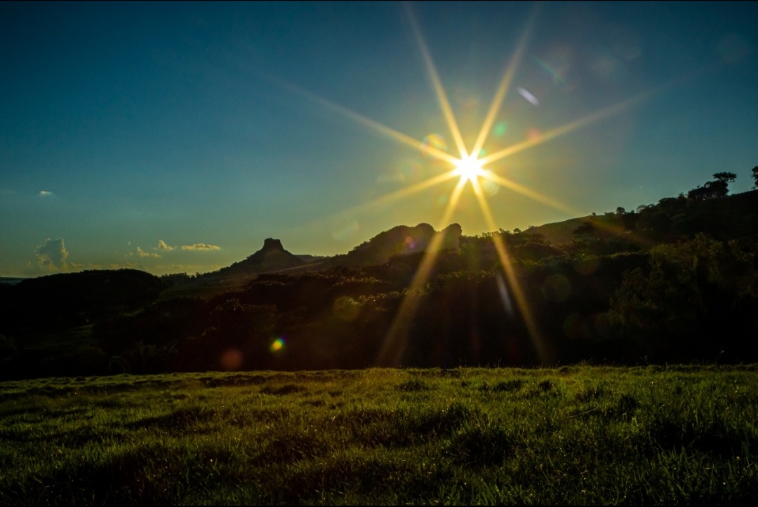 Morros de Analândia (SP) sob o sol baixo, com céu aberto e pastagem em primeiro plano