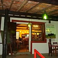 Salão da Cantina Toscana em Analândia (SP), com placa do restaurante, teto de madeira e mesas