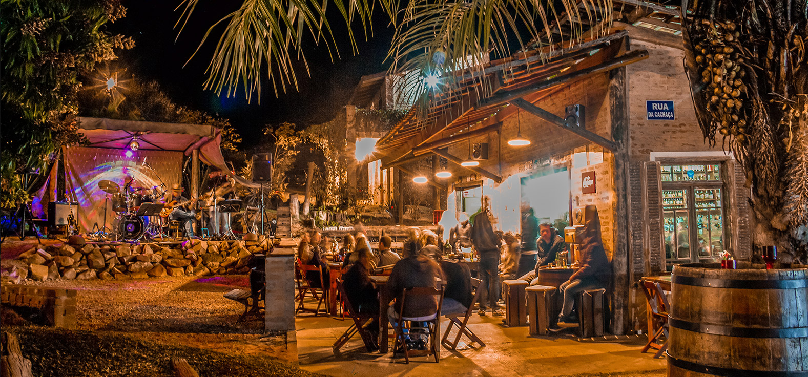 Cachaçaria Macaúva à noite, com mesas ao ar livre e música ao vivo em Analândia (SP)