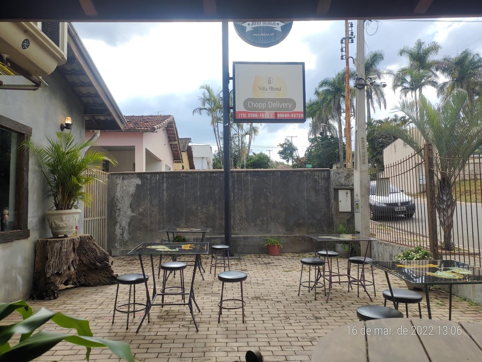 Área externa do Restaurante e Pizzaria Di Maria em Analândia (SP), com mesas altas e piso de pedra