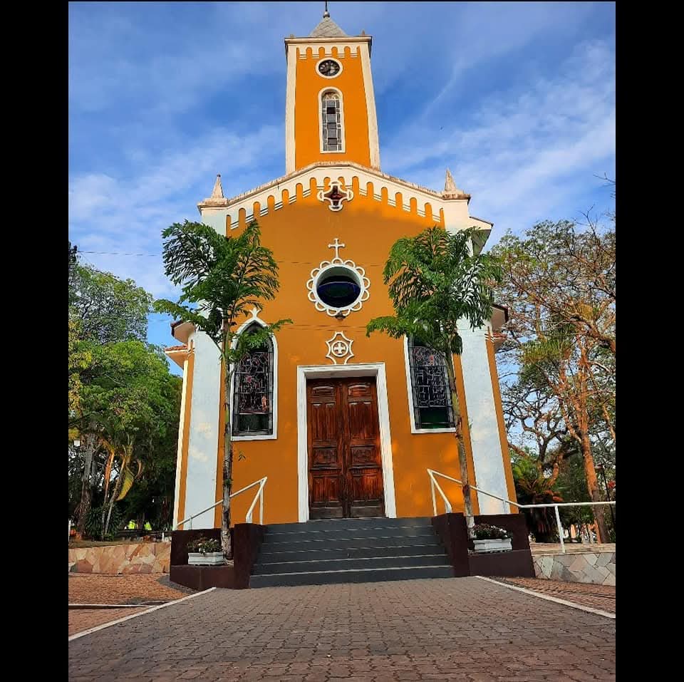 Fachada amarela da Igreja Matriz de Sant’Ana em Analândia (SP), com torre do relógio e escadaria